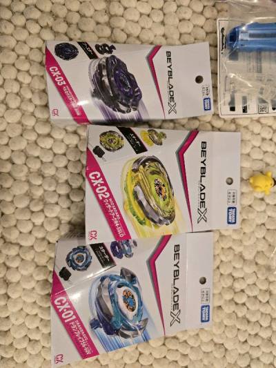 a bunch of new beyblade cx products along with a small purin, looks great
